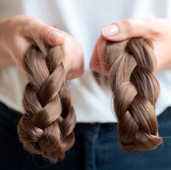 close-up-person-holding-brown-braids